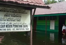 Meski air merendam setinggi mata kaki orang dewasa, SDN Pematang Baru, proses belajar mengajar tetap berlangsung