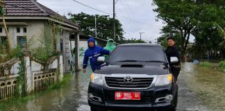 HM. Rofiqi rela tembus genangan air, demi bagikan paket sembako untuk warga
