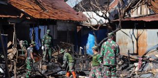 Anggota TNI AD bergotong royong membersihkan lokasi kebakaran di Desa Mekar